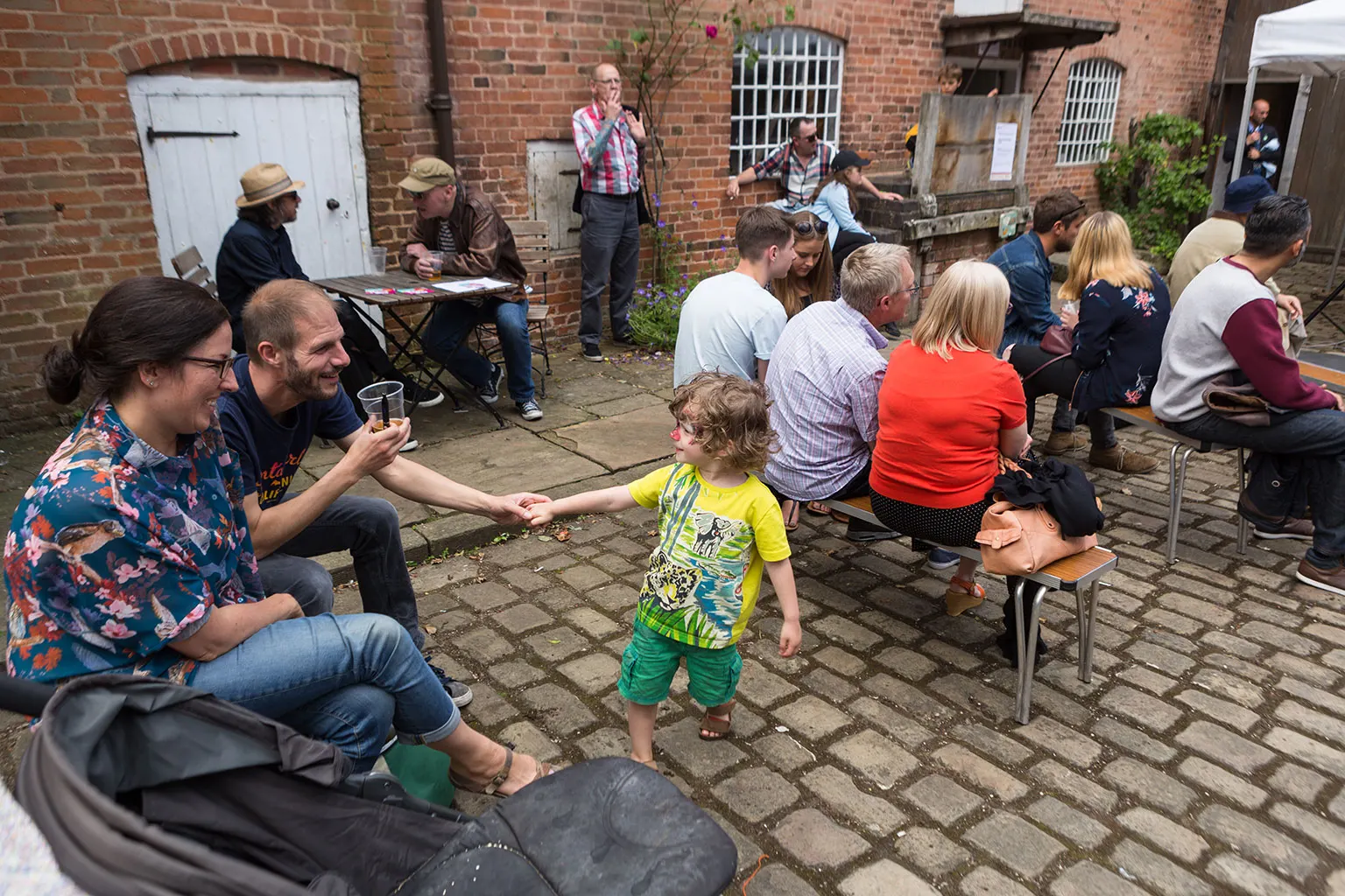 Adults and a child enjoying an outdoor gathering in a courtyard.